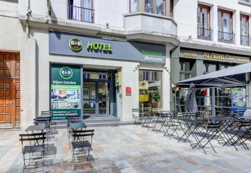 a group of chairs and tables in front of a store at B&B HOTEL Dijon Centre in Dijon