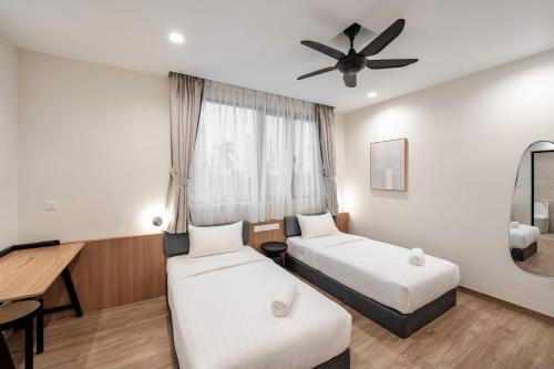 een hotelkamer met 2 bedden en een plafondventilator bij Codrington House - Boutique Apartments in George Town