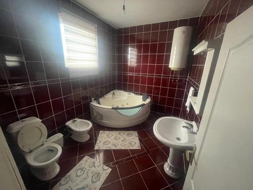 uma casa de banho com 2 WC, uma banheira e um lavatório. em Stan na dan kod sase em Bogatić