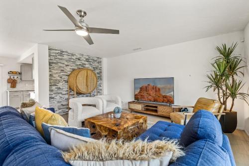 een woonkamer met een blauwe bank en een tafel bij Trendy 3BR in Sedona: Hot Tub/Fire-pit /Central Location in Sedona