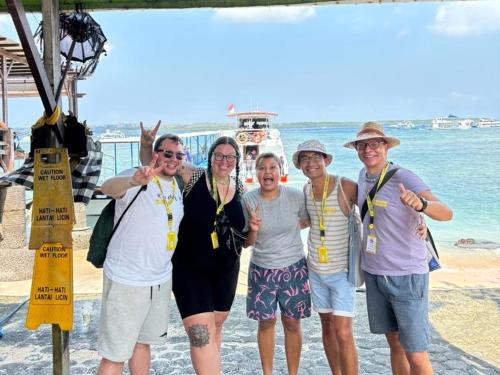 um grupo de mulheres posando para uma foto na praia em citiz house & hostel em Nusa Penida