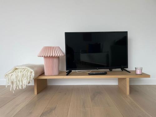 una TV a schermo piatto seduta su un tavolo di legno di #2800ourhome 301 a Mechelen