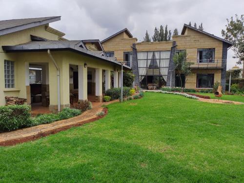 een huis met een gazon ervoor bij Florances Rest House in Nairobi