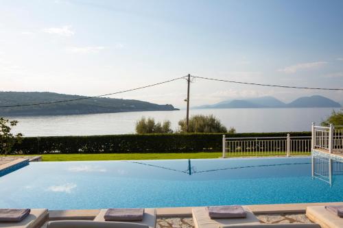 een zwembad met uitzicht op het water bij Ionian Calm Villas in Vasiliki