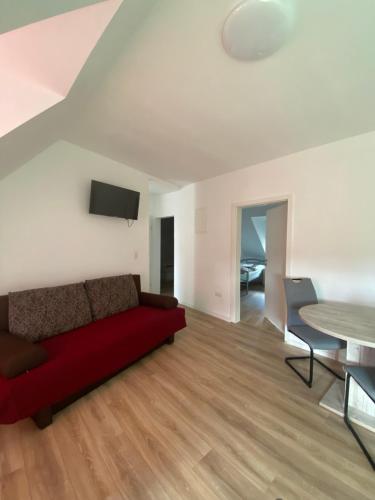 sala de estar con sofá rojo y mesa en Annie´s Appartements, en Mannheim