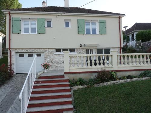 a white house with a white fence and stairs at LES GRADINES in Bar-sur-Aube