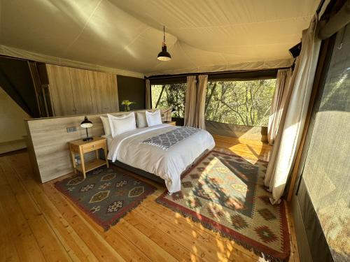 een slaapkamer met een bed in een tent bij Olesamara Collection in Nanyuki