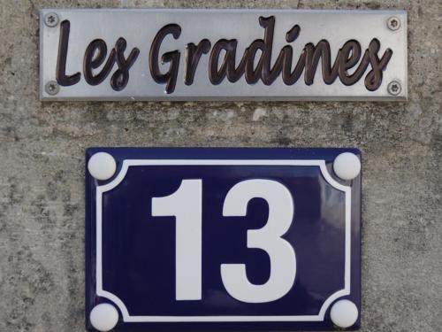 a blue and white sign on a wall with the number thirteen at LES GRADINES in Bar-sur-Aube