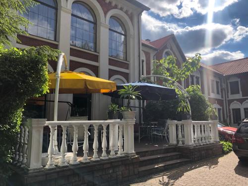 een huis met een balkon met een tafel en een parasol bij Hotel Zameczek in Radomsko