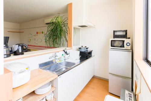 cocina con fregadero y nevera en GUEST HOUSE BLUE DOORS - Vacation STAY 73130v, en Yamagata