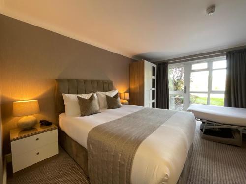 Habitación de hotel con cama grande y ventana en The Riverside, en Salisbury