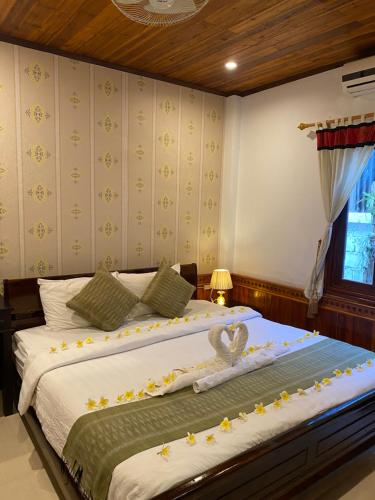 - une chambre avec 2 lits fleuris dans l'établissement Golden Lotus Place, à Luang Prabang