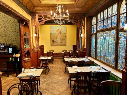 - un restaurant avec des tables et des chaises dans une salle dotée de fenêtres dans l'établissement Hotel Rubenshof, à Anvers