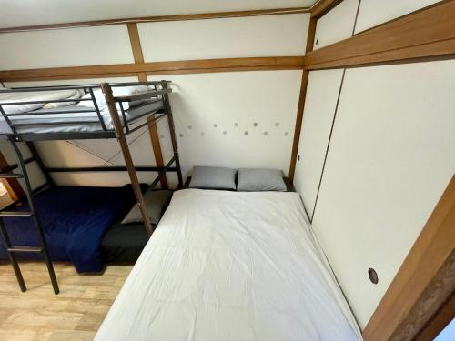 Una cama o camas en una habitación de SunHome コリアタウン近く 一軒家貸切り 今里