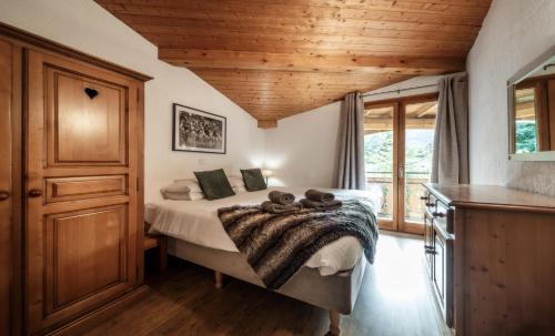 una camera con letto e soffitto in legno di Chalet Sosa a Morzine