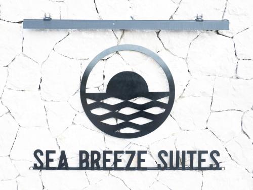 Znak z napisem "Sea Breeze Suites" na kamiennej ścianie w obiekcie Sea breeze suites Mistral 4 per with private pool w mieście Kandia