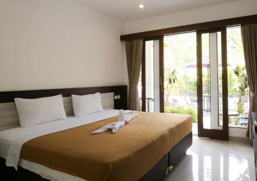 een slaapkamer met een groot bed en een groot raam bij Dewi Villa Padangbai Hotel in Padangbai