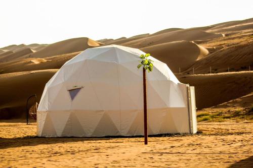 een witte tent midden in een woestijn bij Golden Desert Camp Al Wasil in Al Wāşil