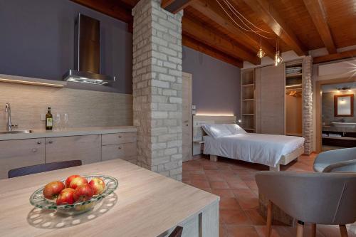 a kitchen and living room with a bowl of fruit on a table at Il Filo Rosso B&B in Abano Terme