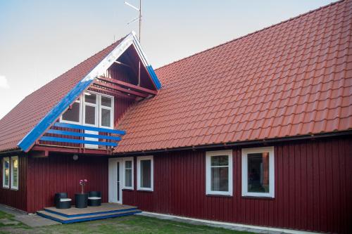 a red house with a red roof at Pervalkos vetrunges in Neringa