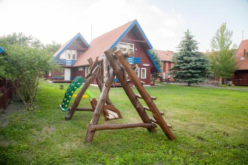 a wooden playground in the yard of a house at Pervalkos vetrunges in Neringa