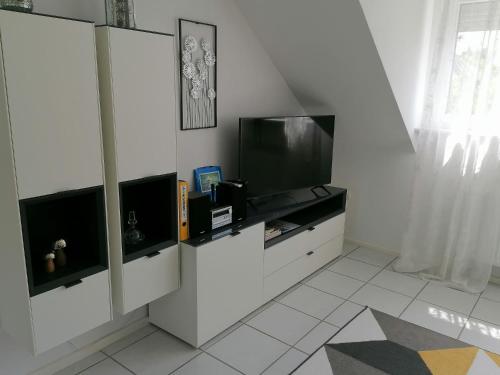 a living room with a tv and a white wall at Ferienwohnung Grete in Trier