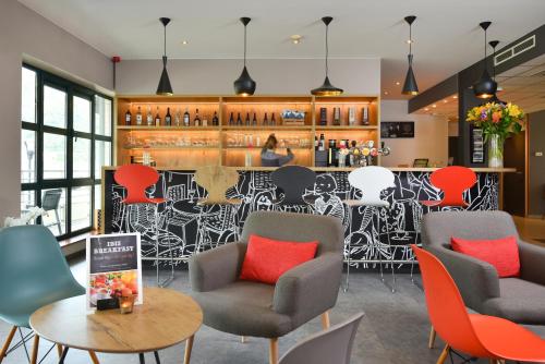 a restaurant with chairs and a bar with a mural at ibis Dinant Centre in Dinant