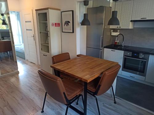 a kitchen with a wooden table and chairs at Na Sadowej in Grodzisk Mazowiecki