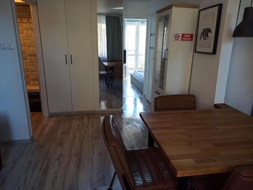 a dining room with a wooden table and chairs at Na Sadowej in Grodzisk Mazowiecki