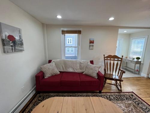 - un salon avec un canapé rouge et une chaise dans l'établissement Bright & Spacious 1 BR- King Bed & Private Yard, à Providence