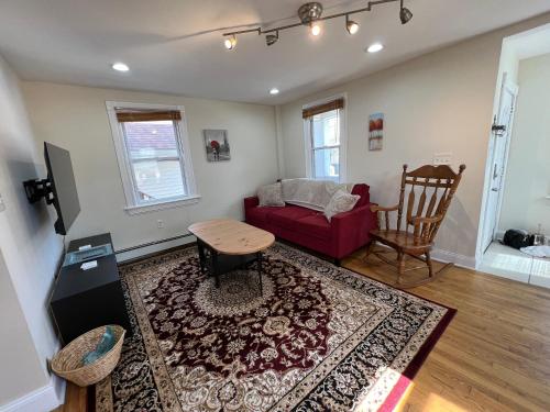 - un salon avec un canapé rouge et une table dans l'établissement Bright & Spacious 1 BR- King Bed & Private Yard, à Providence