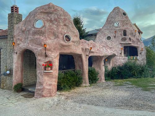 una casa con forma de casa con una planta en una ventana en Anemoessa, en Synikia Mesi Trikalon