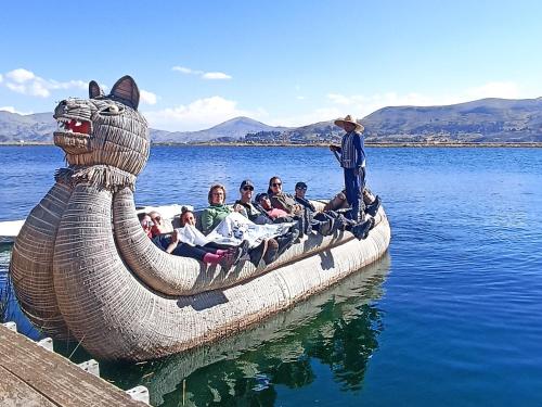 a group of people on alatablelatable boat in the water at Uros Waliski Lodge in Puno