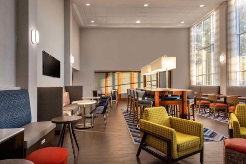 Hampton Inn & Suites State College at Williamsburg Square في ستيت كولج: مطعم فيه كراسي وطاولات وبار