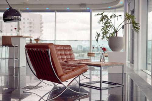 - un salon avec un fauteuil en cuir et une table dans l'établissement DoubleTree by Hilton Rotterdam Centre, à Rotterdam