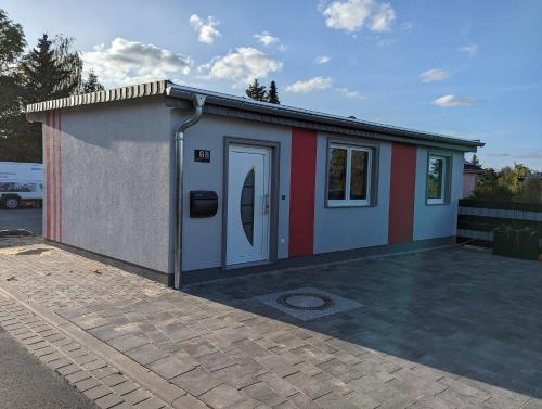 a smallshed with a red and white at Pension Haus Leni am Schwanenteich in Mühlhausen