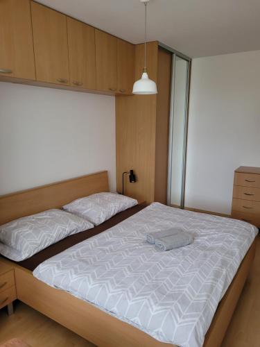 - une chambre avec un grand lit et des draps blancs dans l'établissement Apartmán Neva Trnava, à Trnava