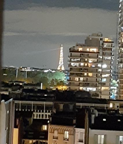 vista su una città di notte con edifici alti di Appartement avec Terrasse à Puteaux 92 a Puteaux