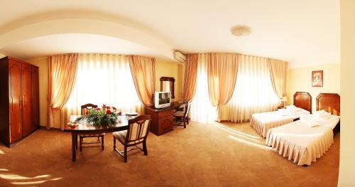 a hotel room with two beds and a table at Hotel Premier in Cluj-Napoca