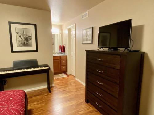 - un salon avec un piano et une télévision sur une commode dans l'établissement Hidden Gem in SE Boise with hot tub and wood burning fireplace, à Boise