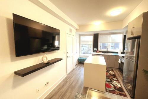 una cucina con una grande TV a schermo piatto a parete di Exquisite, bright & modern condo. a Niagara Falls