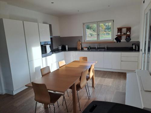 a kitchen with a wooden table and chairs at Aosta Stunning Panoramic Views From Modern Two Bedroom Apartment in Aosta