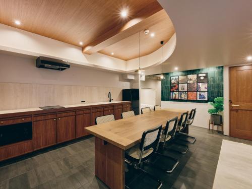 a large kitchen with a large wooden table and chairs at illi Com Shimokitazawa in Tokyo