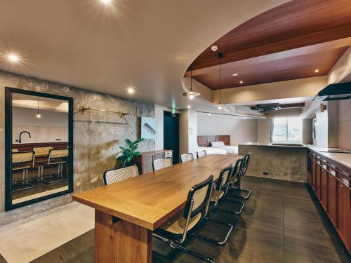 a large wooden table in a room with chairs at illi Com Shimokitazawa in Tokyo