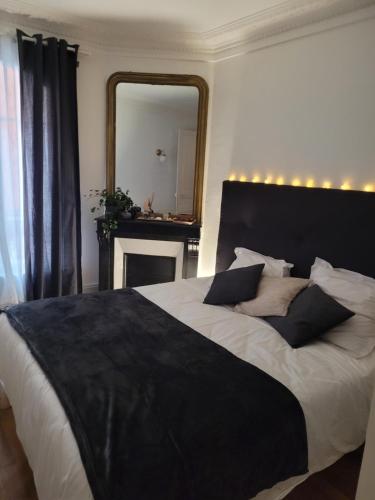 a bedroom with a large bed with a large mirror at L'appartement Idéal 4 voyageurs in Boulogne-Billancourt