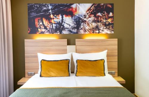 1 dormitorio con 1 cama con almohadas amarillas en Leonardo Boutique Hotel Salzburg Gablerbräu, en Salzburgo