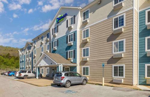 een auto geparkeerd voor een groot gebouw bij Extended Stay America Select Suites - Fayetteville - I-49 in Fayetteville