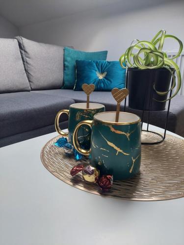 two coffee mugs on a tray on a coffee table at COMFORT Suites VELIKA GORICA in Velika Gorica