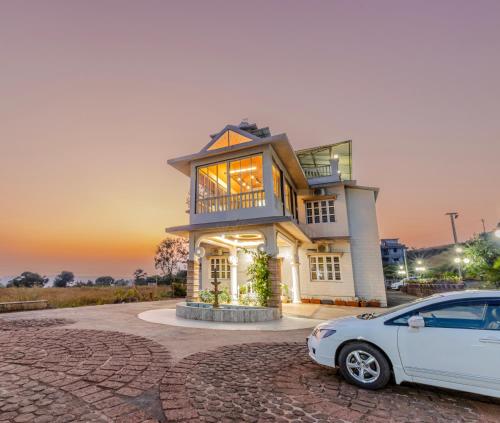 een witte auto geparkeerd voor een huis bij Silver Galaxy Resort in Panchgani