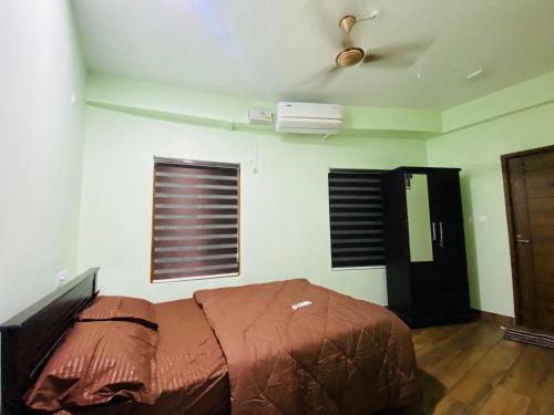 een slaapkamer met een bed en een plafondventilator bij AL-Kabeer Lavender budget rooms in Trivandrum